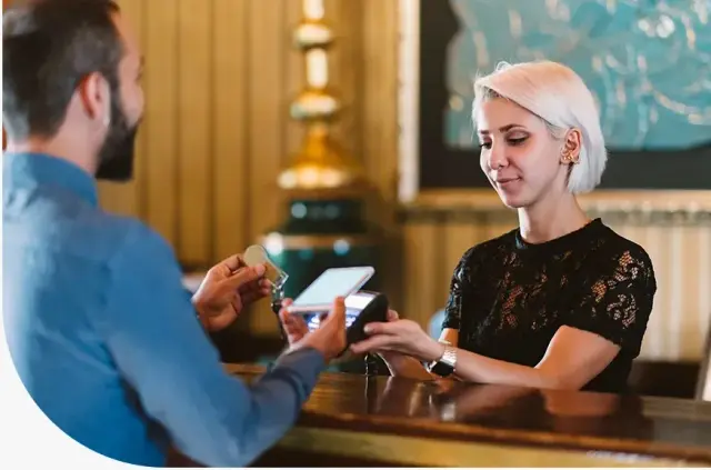 Customer paying at a service counter with a card machine